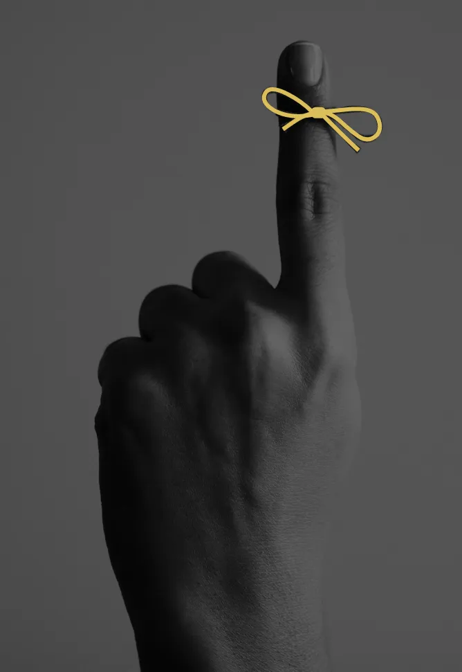 Index finger with a gold ribbon around it